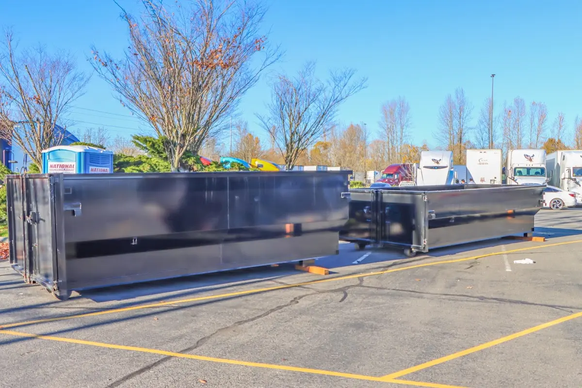 Professional dumpster rental service with roll-off container on residential driveway in Westford